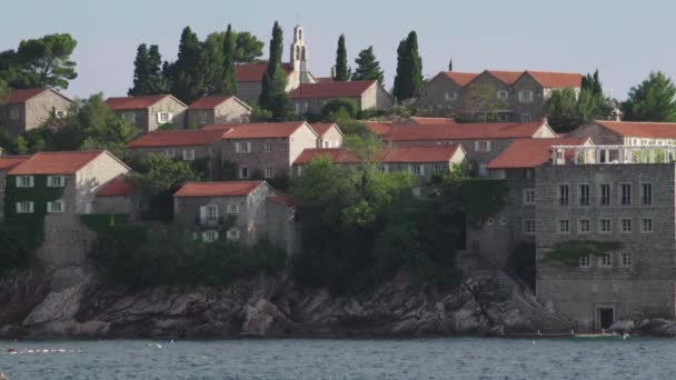 Casas con tejados de tejas rojas. Arquitectura de Sveti Stefan. Montenegro . — Vídeo de stock