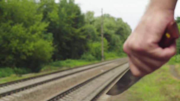 Маньяк с ножом возле железнодорожных путей . — стоковое видео