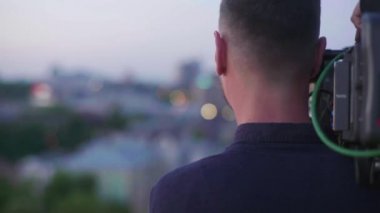 Çekim sırasında elinde kamera olan bir kameraman. Film yapımcılığı. Çekim.