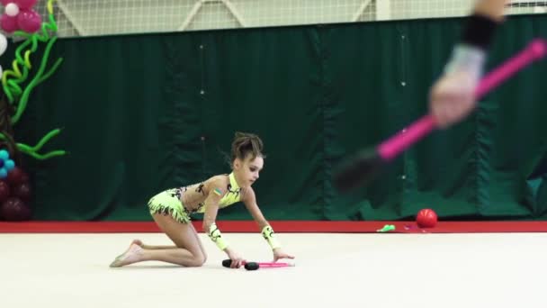 Girl gymnast with clubs during the competition. Slow motion. Kyiv. Ukraine.