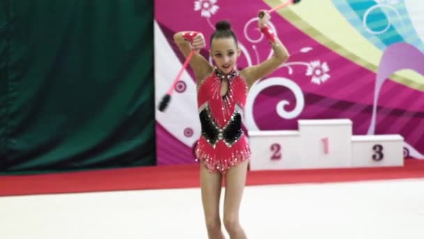 Chica gimnasta con clubes durante la competición. En cámara lenta. Kiev. Ucrania . — Vídeos de Stock