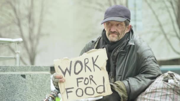 Tulisan "Bekerja untuk makanan" oleh gelandangan tunawisma miskin. Kyiv. Ukraina — Stok Video