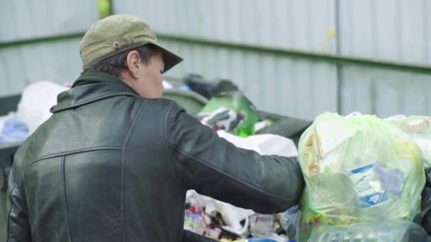 Un vagabundo mendigo sin hogar está buscando comida en un cubo de basura. Kiev. Ucrania — Vídeos de Stock