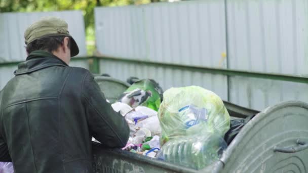 거지같은 노숙자 한 명 이 쓰레기통에서 먹이를 찾고 있습니다. 키프. 우크라 이나 — 비디오