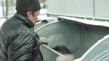 Dilenci evsiz bir serseri çöp tenekesinde yiyecek arıyor. Kyiv. Ukrayna