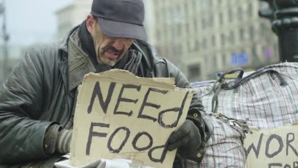 L'iscrizione "Need food" di un povero vagabondo senzatetto. Kiev. Ucraina — Video Stock