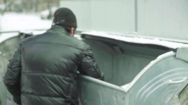 Dilenci evsiz bir serseri çöp tenekesinde yiyecek arıyor. Kyiv. Ukrayna