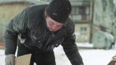 Dilenci evsiz bir serseri çöp tenekesinde yiyecek arıyor. Kyiv. Ukrayna