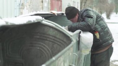 Dilenci evsiz bir serseri çöp tenekesinde yiyecek arıyor. Kyiv. Ukrayna