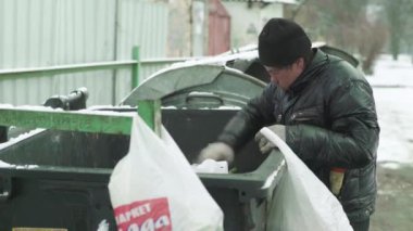 Dilenci evsiz bir serseri çöp tenekesinde yiyecek arıyor. Kyiv. Ukrayna