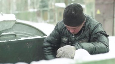 Dilenci evsiz bir serseri çöp tenekesinde yiyecek arıyor. Kyiv. Ukrayna