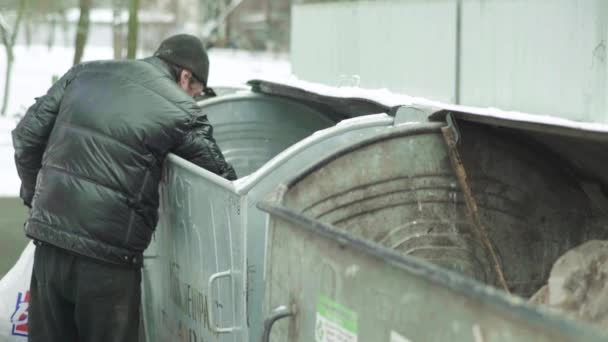 Ein Bettler, der obdachlos ist, sucht in einem Mülleimer nach Essen. Kiew. Ukraine — Stockvideo