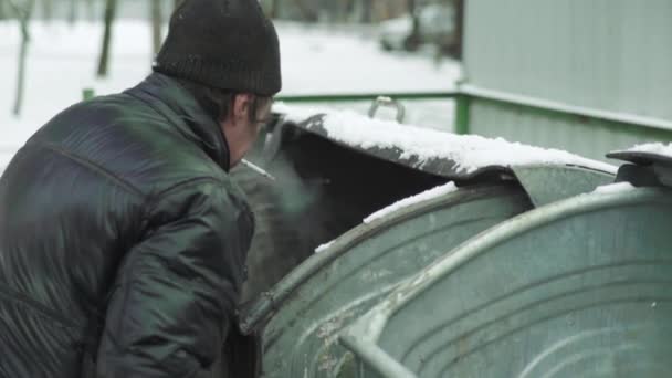 Ein Bettler, der obdachlos ist, sucht in einem Mülleimer nach Essen. Kiew. Ukraine — Stockvideo