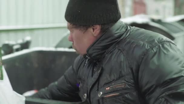 Ein Bettler, der obdachlos ist, sucht in einem Mülleimer nach Essen. Kiew. Ukraine — Stockvideo