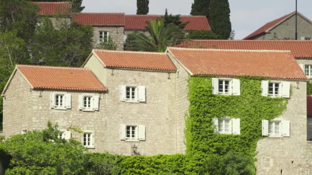 Hus med röda kaklade tak. Arkitektur Sveti Stefan. Montenegro. — Stockvideo