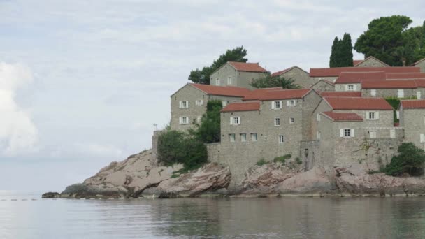 Huizen met rode betegelde daken. Architectuur van Sveti Stefan. Montenegro. — Stockvideo