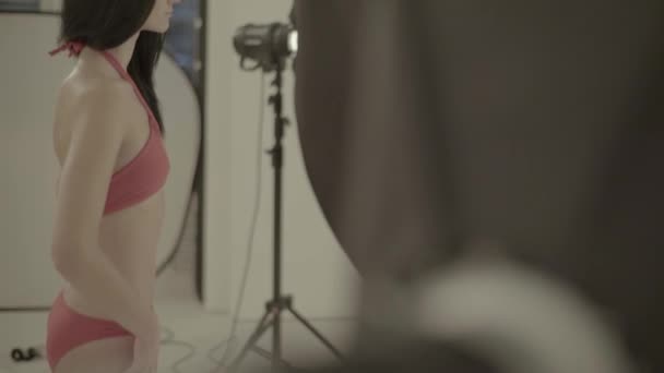 Fotografía entre bastidores. Sesión de fotos. Modelo posando al fotógrafo . — Vídeo de stock