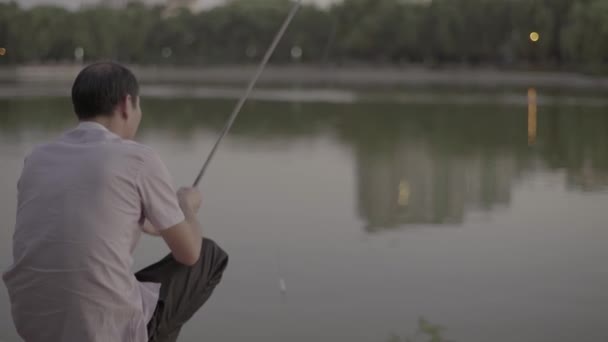 Pescador pega peixe no lago. Pequim. A China. Ásia — Vídeo de Stock