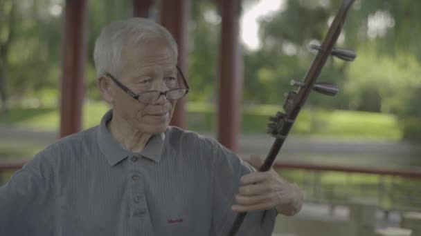 Mužský hudebník hraje v parku. Peking. Čína. Asie — Stock video