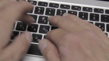 Eller Macbook klavyesine yazı yazıyor. Yakın plan.