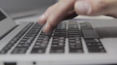 Eller Macbook klavyesine yazı yazıyor. Yakın plan.