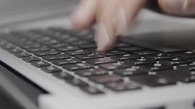 Eller Macbook klavyesine yazı yazıyor. Yakın plan.