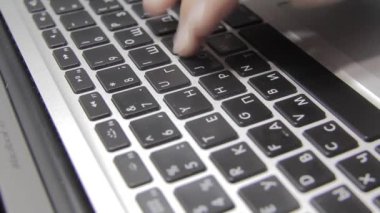 Eller Macbook klavyesine yazı yazıyor. Yakın plan.
