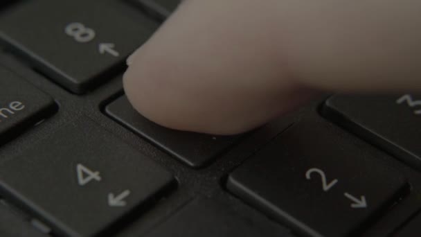 The finger presses a button with a number on the keyboard — Stock Video