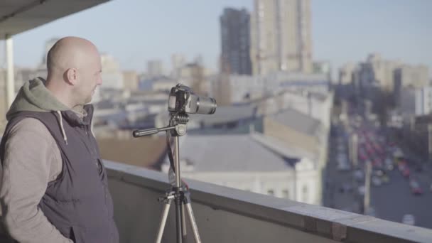 Man manlig kameraman fotograf med en kamera Dslr på ett stativ i staden skjuter video foto. Kiev. Ukraina — Stockvideo