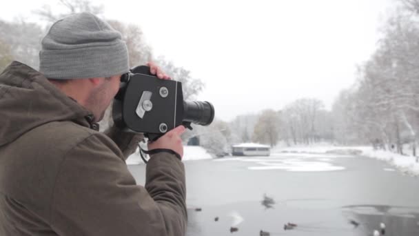 Erkek bir kameraman kışın Krasnogorsk parkında eski bir vintage kamera ile video çekiyor. Kyiv. Ukrayna — Stok video