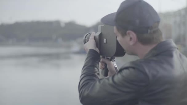 Um cameraman macho filma vídeo em uma velha câmera vintage Krasnogorsk. Kiev. Ucrânia — Vídeo de Stock