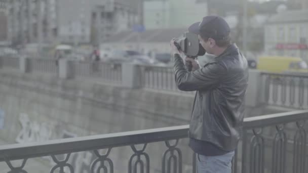 男性カメラマンが古いヴィンテージカメラKrasnogorskでビデオを撮影します。キエフ。ウクライナ — ストック動画