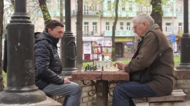 Осенью пенсионеры играют в шахматы в парке. Киев, Украина — стоковое видео