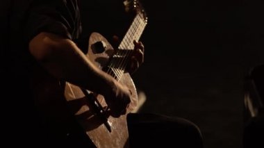 Male guitarist plays the guitar in the dark. Kyiv. Ukraine