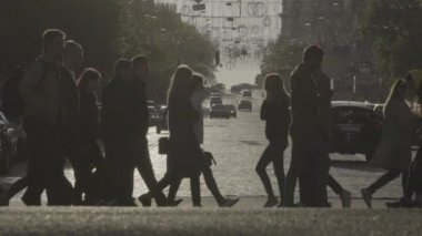 İnsanlar yaya geçidinde karşıdan karşıya geçiyorlar. Kalabalık. Kyiv. Ukrayna. Yavaş çekim.