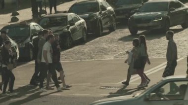 İnsanlar yaya geçidinde karşıdan karşıya geçiyorlar. Kalabalık. Kyiv. Ukrayna. Yavaş çekim.