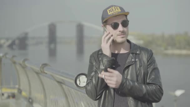 Killen pratar i mobilen och röker. — Stockvideo