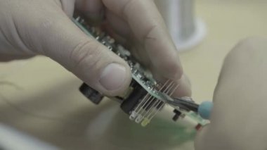 Bir işçi bir elektronik pano üretimi üzerinde çalışıyor. Yakın plan..