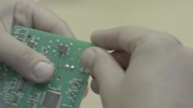 Bir işçi bir elektronik pano üretimi üzerinde çalışıyor. Yakın plan..