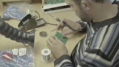 Bir işçi bir elektronik pano üretimi üzerinde çalışıyor. Yakın plan..