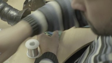 Bir işçi bir elektronik pano üretimi üzerinde çalışıyor. Yakın plan..