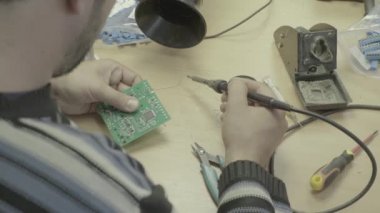 Bir işçi bir elektronik pano üretimi üzerinde çalışıyor. Yakın plan..