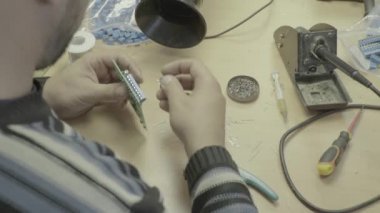 Bir işçi bir elektronik pano üretimi üzerinde çalışıyor. Yakın plan..