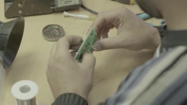Bir işçi bir elektronik pano üretimi üzerinde çalışıyor. Yakın plan..