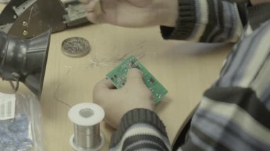 Bir işçi bir elektronik pano üretimi üzerinde çalışıyor. Yakın plan..