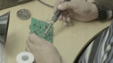 Bir işçi bir elektronik pano üretimi üzerinde çalışıyor. Yakın plan..