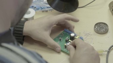 Bir işçi bir elektronik pano üretimi üzerinde çalışıyor. Yakın plan..