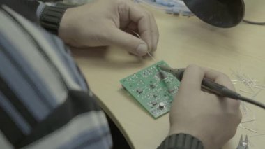 Bir işçi bir elektronik pano üretimi üzerinde çalışıyor. Yakın plan..