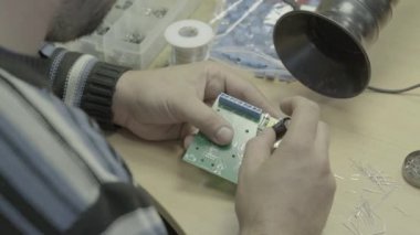 Bir işçi bir elektronik pano üretimi üzerinde çalışıyor. Yakın plan..