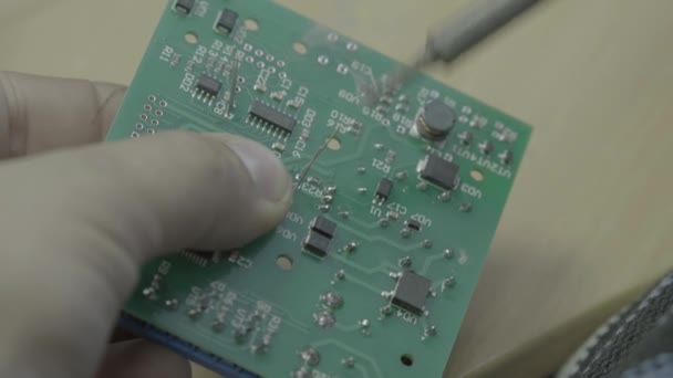 Egy munkás egy elektronikus tábla gyártásán dolgozik. Közelkép. — Stock videók
